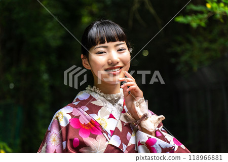 A woman in a kimono walking around town A woman in a kimono walking around town 118966881