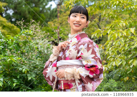 A woman in a kimono walking around town 118966935