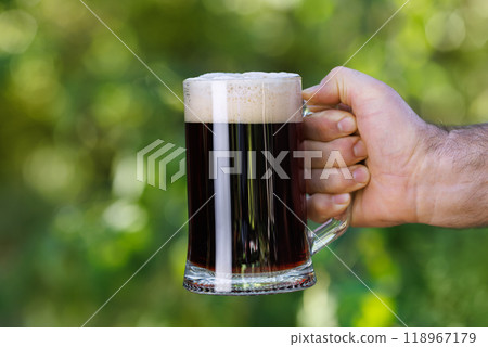 closeup male hand with mug of dark beer 118967179