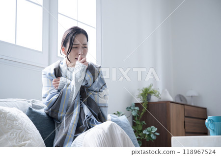 一名婦女在家中因感冒或發燒而出現喉嚨痛,身體不適並出現咳嗽症狀。 一名婦女在家中因感冒或發燒而出現喉嚨痛,身體不適並出現咳嗽症狀。 118967524