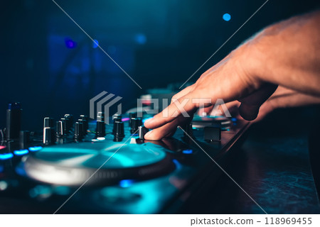 DJ controls and mix music on music mixer in nightclub DJ controls and mix music on music mixer in nightclub 118969455