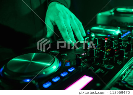 hand moving of DJ controllers on music control panel in night club hand moving of DJ controllers on music control panel in night club 118969470