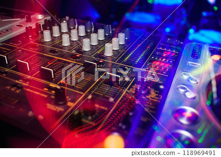 music dj panel mixer in a booth at a nightclub music dj panel mixer in a booth at a nightclub 118969491