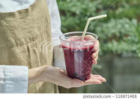 Woman holding a blueberry smoothie 118971408