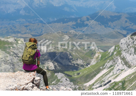 Woman Sitting on Mountain Summit Cliff after Climbing 118971661