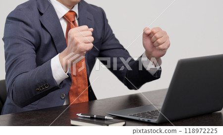 A businessman posing in front of a computer A businessman posing in front of a computer 118972225