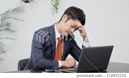 A businessman worried in front of a computer A businessman worried in front of a computer 118972228