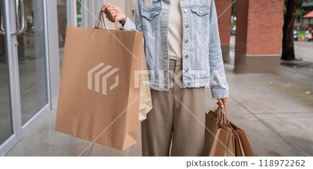 Modern Shopper Displaying Large Shopping Bags Post Black Friday Purchases 118972262