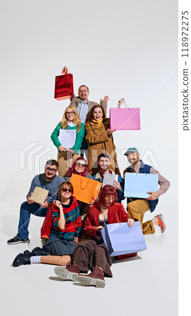 Crowd of people forming a human tower, showing their excitement about shopping, holding many colorful shopping bags Crowd of people forming a human tower, showing their excitement about shopping, holding many colorful shopping bags 118972275