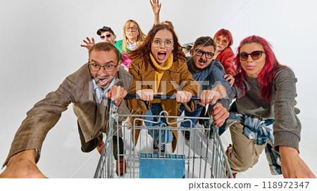 Group of super emotional and excited people pushing shopping cart forward with craziness. Competition for best deals 118972347