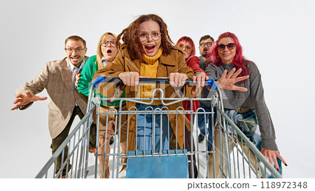 Group of super emotional and excited people pushing shopping cart forward with craziness. Competition for best deals 118972348