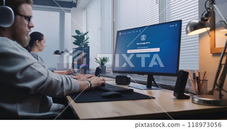 Adult man in headphones enters prompt in AI image generator on computer 118973056