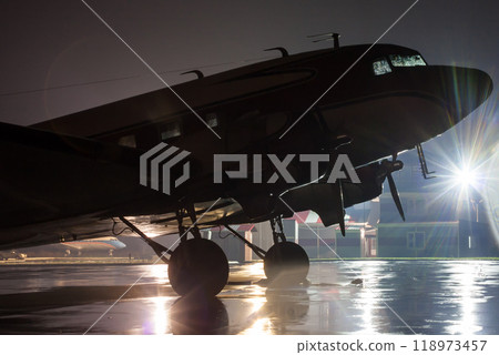 Retro airplane on the rainy night at the airport Retro airplane on the rainy night at the airport 118973457