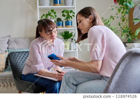 Female psychologist with clipboard working with young woman patient in office 118974526
