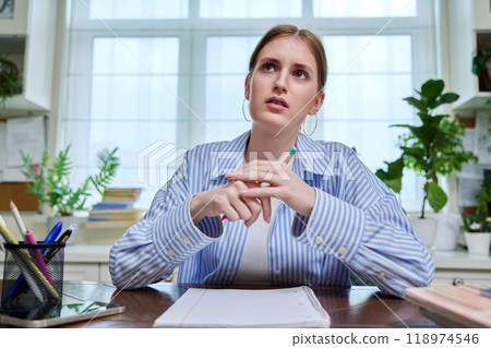 Webcam portrait of teenage female student, sitting at home at desk Webcam portrait of teenage female student, sitting at home at desk 118974546