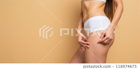 Anti-cellulite cream advertisement showing woman applying lotion on legs to reduce stretch marks and improve skin texture. Cosmetic treatment for smoother, firmer skin Anti-cellulite cream advertisement showing woman applying lotion on legs to reduce stretch marks and improve skin texture. Cosmetic treatment for smoother, firmer skin 118974673