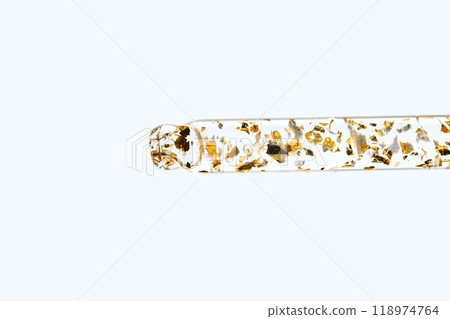 Transparent test tube with gold flakes on white background, modern minimalist Transparent test tube with gold flakes on white background, modern minimalist 118974764