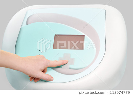 Futuristic medical device interface with human hand pressing touch screen button 118974779