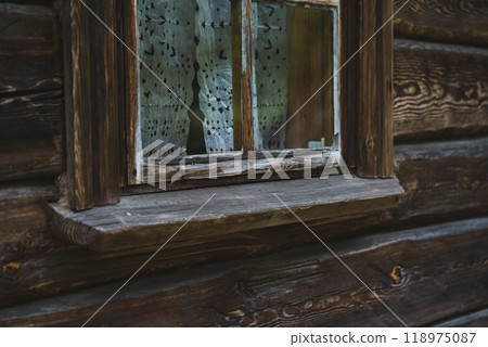 An old window of an Old Slavic, rustic house. Wooden house An old window of an Old Slavic, rustic house. Wooden house 118975087