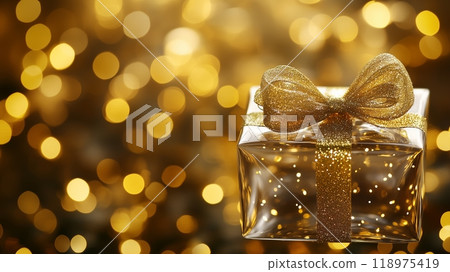 Transparent glass Christmas gift with a festive golden bokeh background. 118975419