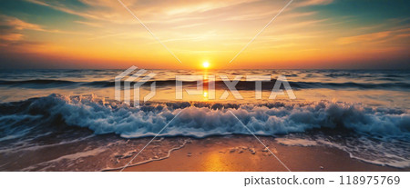 Waves crashing on the shore at sunset with golden light 118975769