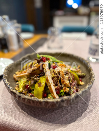 Vibrant salad is artfully presented in a rustic bowl, featuring grilled chicken, fresh greens, avocado slices, pomegranate seeds, and crunchy nuts. Appetizing dish highlights a colorful and healthy Vibrant salad is artfully presented in a rustic bowl, featuring grilled chicken, fresh greens, avocado slices, pomegranate seeds, and crunchy nuts. Appetizing dish highlights a colorful and healthy 118976670
