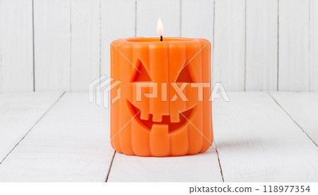 Jack-O'-Lantern Halloween Candle Lit on White Wooden Background for Festive Decor Jack-O'-Lantern Halloween Candle Lit on White Wooden Background for Festive Decor 118977354