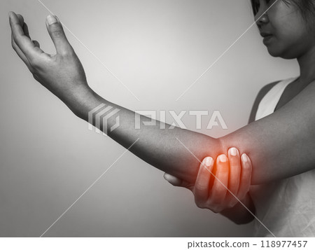 Woman with acute pain elbow with arm pain on gray background, Elbow and arm treatment, Female massaging her elbow muscle spasm, Healthcare and medical concept, Injuries and medical concept. 118977457