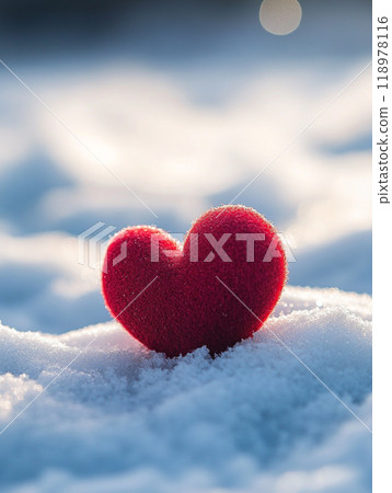A red heart is sitting on top of the snow. The heart is surrounded by a white blanket of snow. Concept of love and warmth. 118978116