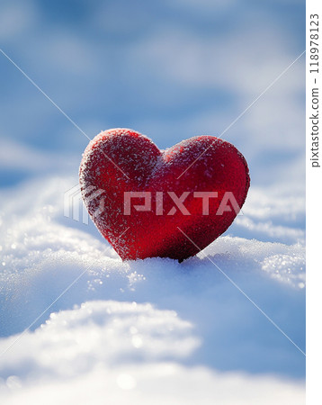 A red heart is sitting on top of the snow. The heart is surrounded by a white blanket of snow. Concept of love and warmth. 118978123