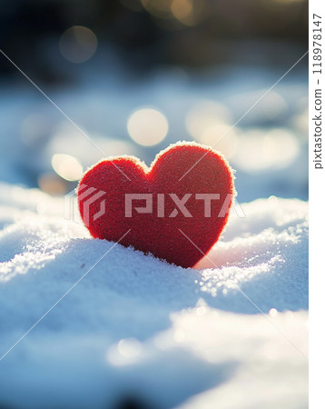 A red heart is sitting on top of the snow. The heart is surrounded by a white blanket of snow. Concept of love and warmth. A red heart is sitting on top of the snow. The heart is surrounded by a white blanket of snow. Concept of love and warmth. 118978147