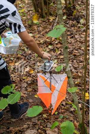 A man punching at the orienteering control point A man punching at the orienteering control point 118978327