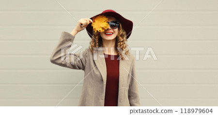 Autumn portrait of beautiful happy smiling woman with yellow maple leaves, stylish joyful girl Autumn portrait of beautiful happy smiling woman with yellow maple leaves, stylish joyful girl 118979604