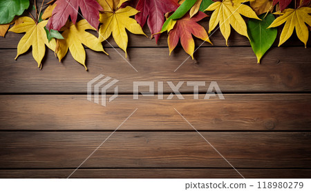 Wooden table with colorful autumn leaves on it creating a frame around the background copy space for advertising text. Top view 118980279