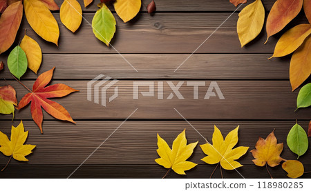 Wooden table with colorful autumn leaves on it creating a frame around the background copy space for advertising text. Top view 118980285