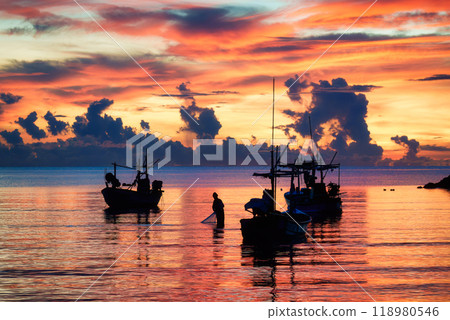 Colorful sunrise sky over fishing boat in tropical sea by the jetty 118980546