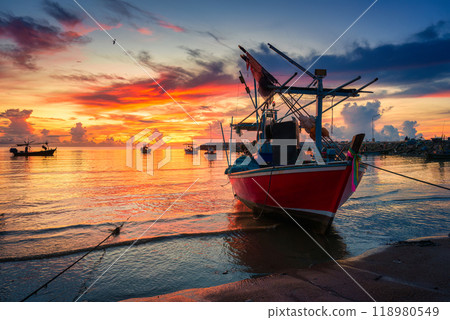 Colorful sunrise sky over fishing boat in tropical sea by the jetty 118980549