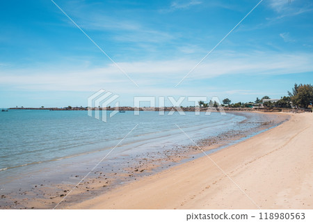 Tropical sea beach with fishing boat by stone jetty in summer Tropical sea beach with fishing boat by stone jetty in summer 118980563
