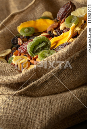 Dried tropical fruits and nuts in burlap bag. 118981023