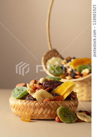 Dried tropical fruits, nuts and raisins on a beige background. 118981025