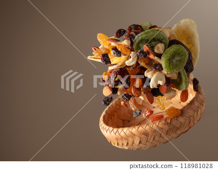 Dried tropical fruits with various nuts and raisins in motion. 118981028