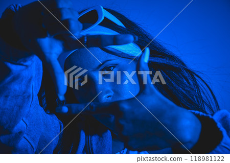 A woman is posing for a picture with her hands in a frame. Urban dancer concept A woman is posing for a picture with her hands in a frame. Urban dancer concept 118981122