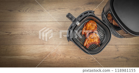 Fresh delicious steaks prepared in airfryer no fat by circulating hot air inside the basket. Long banner format. top view. copy space Fresh delicious steaks prepared in airfryer no fat by circulating hot air inside the basket. Long banner format. top view. copy space 118981155