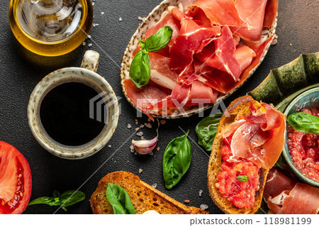Tapas bread with ripe tomatoes and ham. Traditional Spanish breakfast 118981199