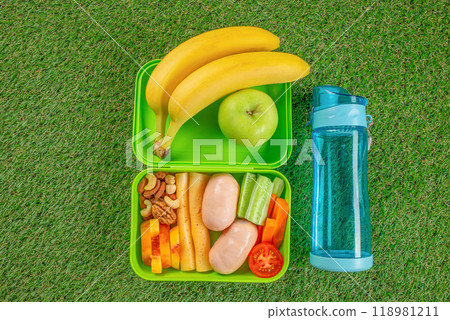 Lunch box glass bottle with water on grass. Healthy picnic at the park 118981211