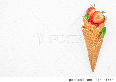 fresh strawberries and icecream cones, berry fruit in waffle cone on a light background, top view. copy space fresh strawberries and icecream cones, berry fruit in waffle cone on a light background, top view. copy space 118981332