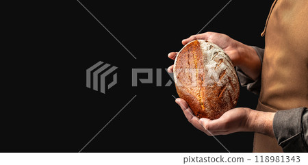 male baker holds homemade freshly baked rye gluten free bread, Long banner format. copy space for text 118981343