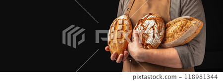 Set of fresh breads in the baker's hands. gluten free bread bakery products on a dark background. Long banner format 118981344