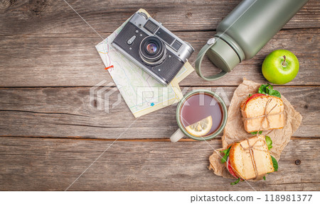 Travel lunch sandwiches and tea on wooden table background, top view. concept of vacation, tourism Travel lunch sandwiches and tea on wooden table background, top view. concept of vacation, tourism 118981377