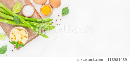 Fresh asparagus on wood board ready for cooking on a white background. cooking concept. Long banner format. top view. copy space for text 118981489
